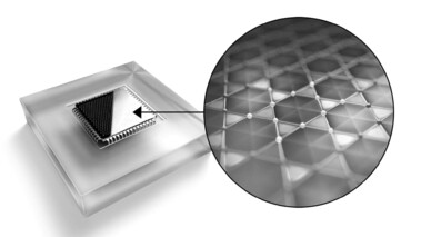Glänzender Quantenchip mit abstrahlendem Licht, auf einer weißen Fläche liegend.